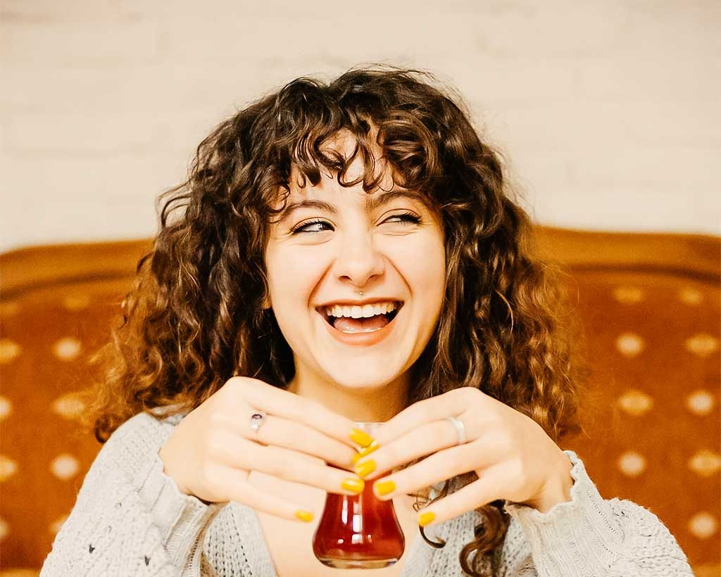 Internationale Frauenteestube. Eine Fraz trinkt türkischen Tee.